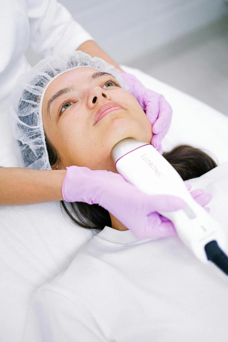 Paciente recebendo tratamento facial com aparelho estético